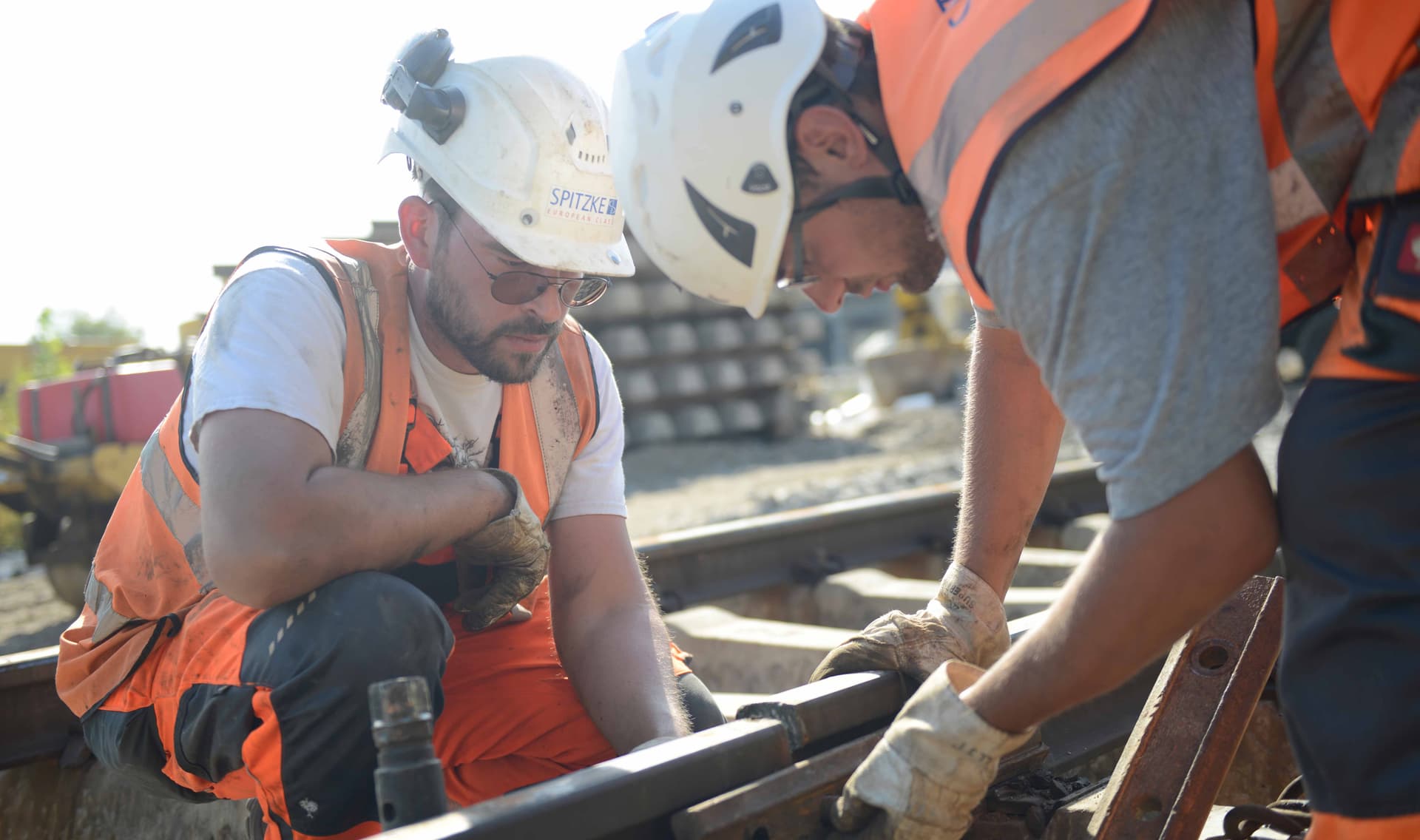 Gleisbauer arbeiten an Bahnschienen.