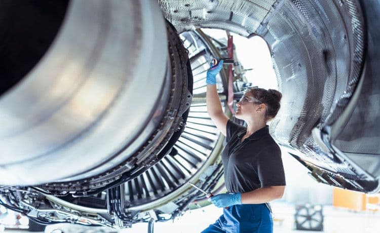 Astronautin repariert eine Maschine.