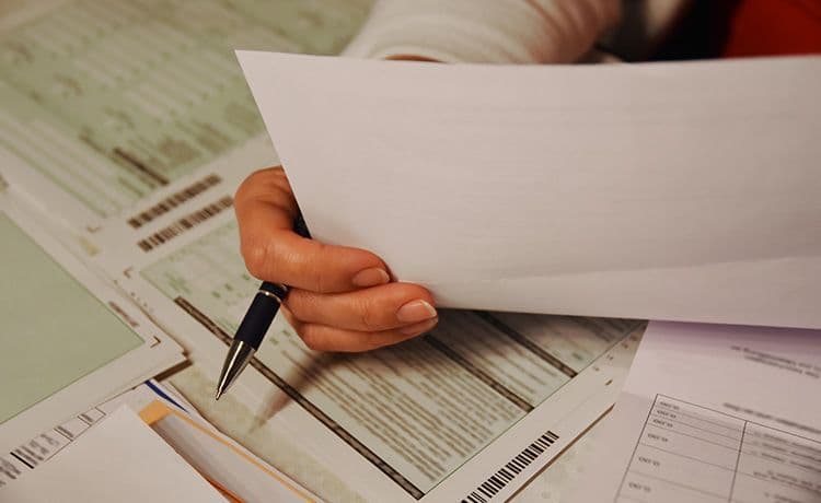 Steuerberater hält eine Steuererklärung in der Hand.