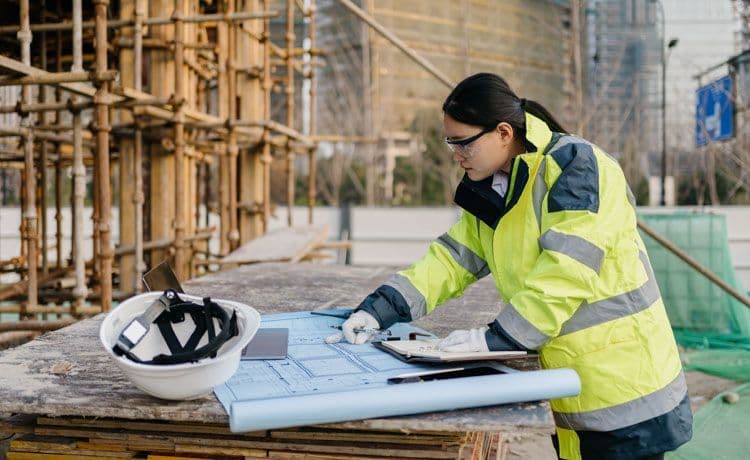Eine junge Bauzeichnerin auf einer Baustelle