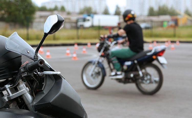 Junger Mann übt Motorradfahren auf einem Übungsplatz.