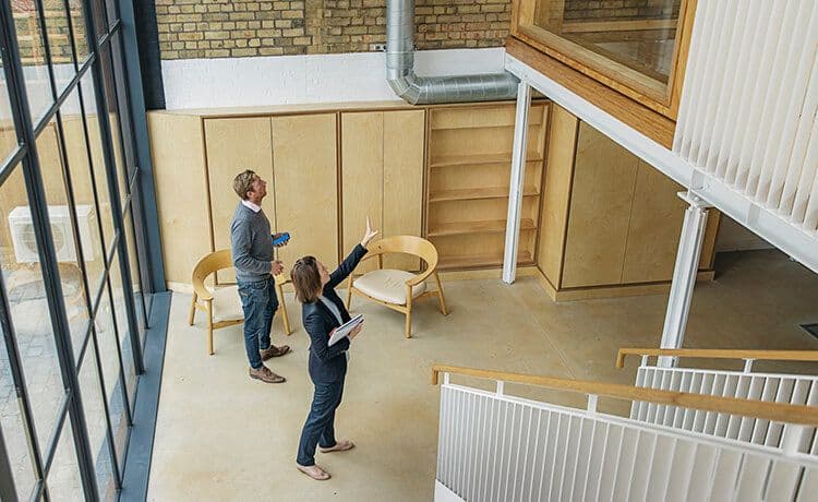 Ein Immobilienkaufmann und eine Immobilienkauffrau schauen sich zusammen eine Wohnung an.