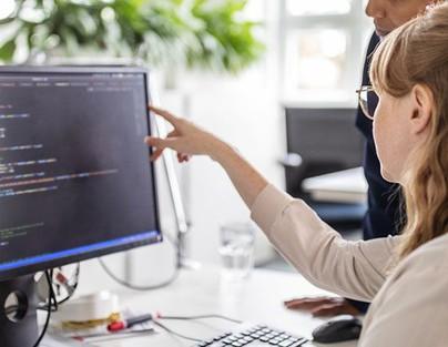 Eine Fachinformatikerin mit ihrem Kollegen bei der Arbeit am Rechner