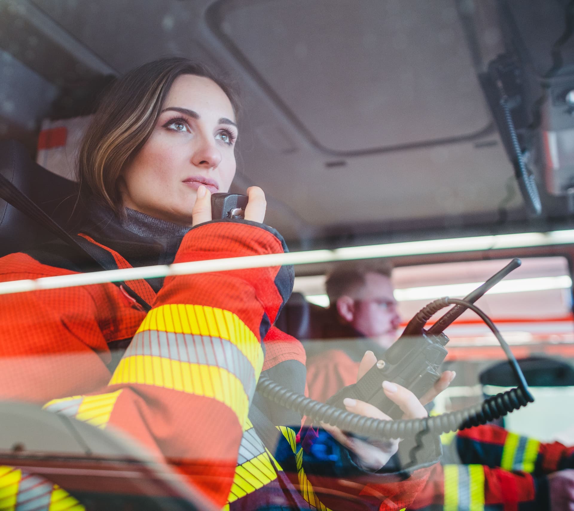 Feuerwehrfrau im Auto gibt einen Funkspruch durch.
