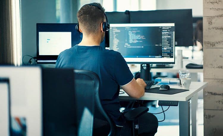 Programmierer sitzt vor einem Computer und codet.