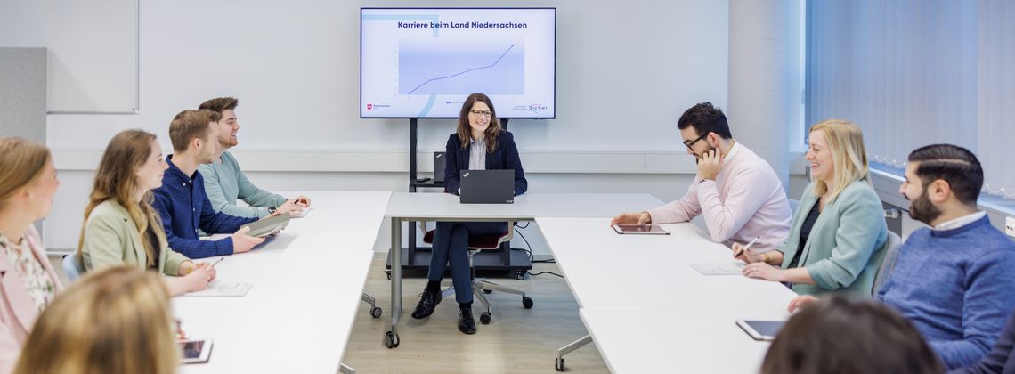 Meeting mit Azubis, die an Tischen sitzen.