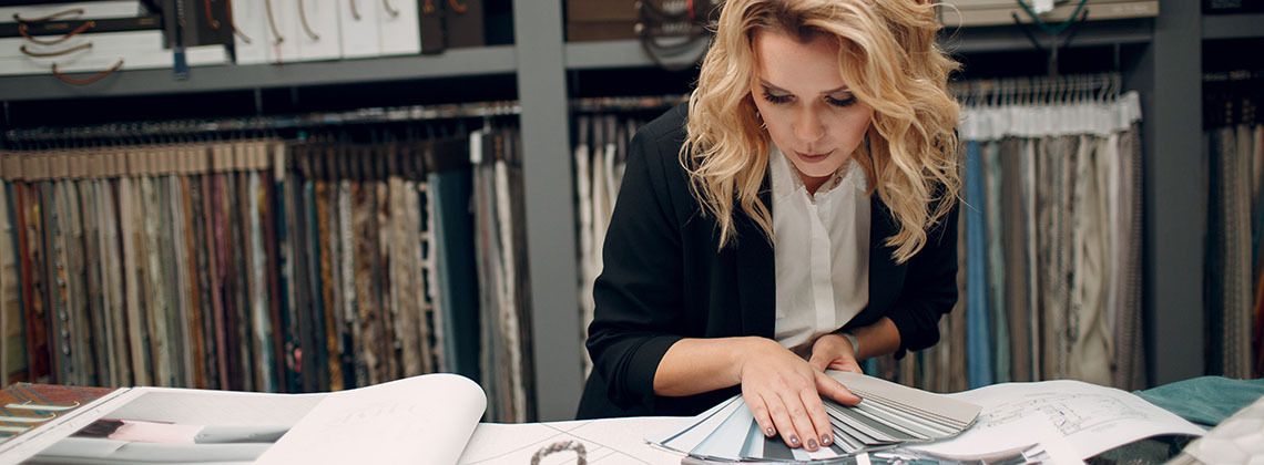 Raumausstatterin bei der Auswahl von Farben für Vorhänge.