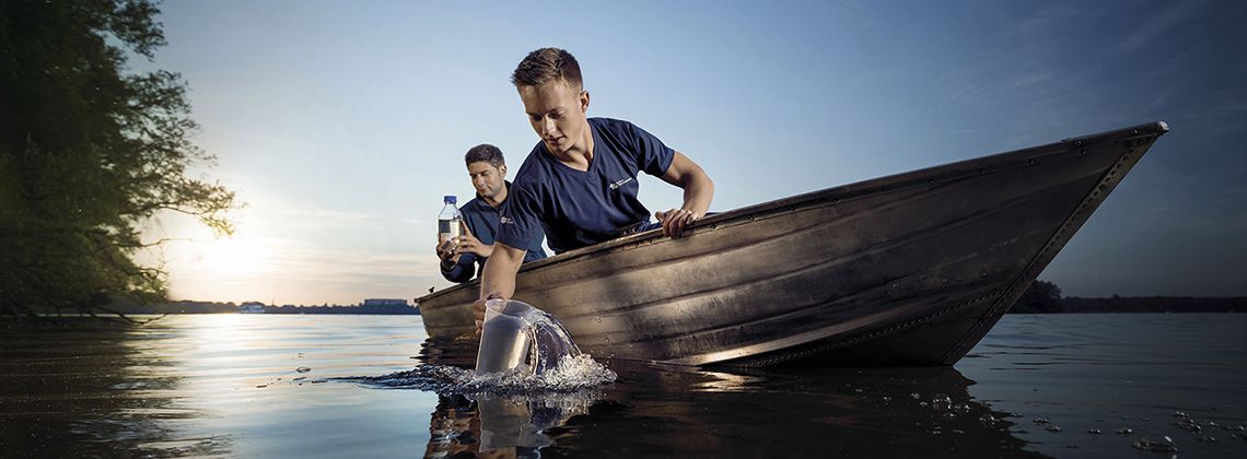 Umwelttechnologen für Wasserversorgung entnehmen Wasserproben auf einem See.