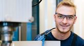 Konstruktionsmechaniker mit Schutzbrille schaut in die Kamera. 