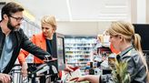 Kauffrau im Einzelhandel bei der Arbeit an der Kasse.